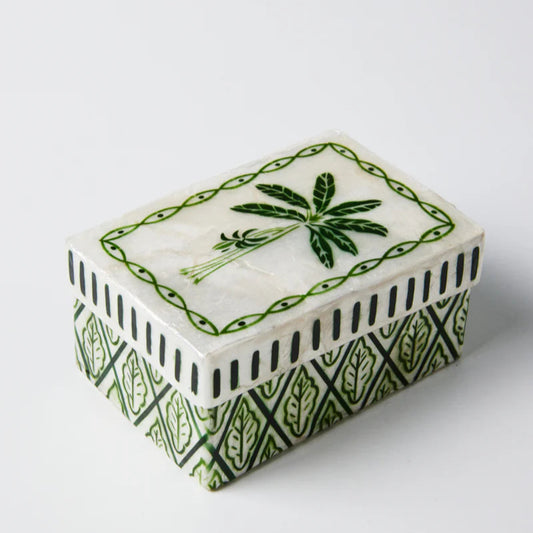 A close-up image of the Atlantic Green Palm box by Jones and Co. The lid has a painted illustration of a palm tree with a decorative edging. 