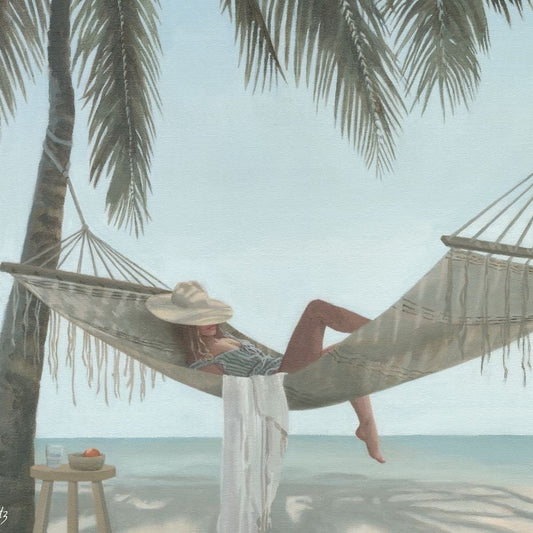 The beach scene will cary you away. The image shows a lady resting on a hammock beneath palm trees. She has a sun hat on to shade her face. beside her is the white sandy beach and ocean