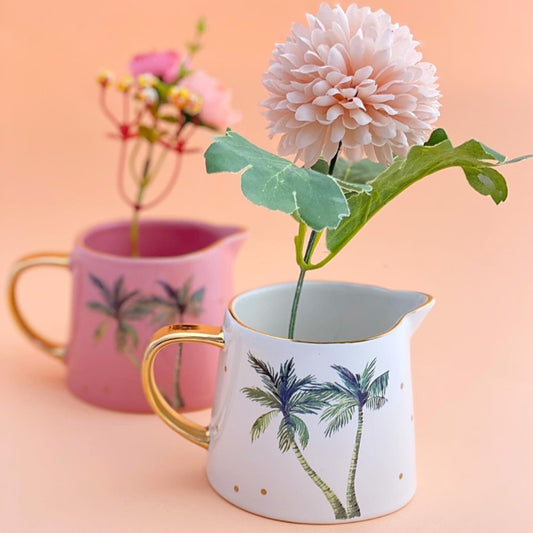 This image shows the white mini tropical jug by Carla Dinnage. with her feature gold spots and gold rim, the main design features 2 palm trees in green. 