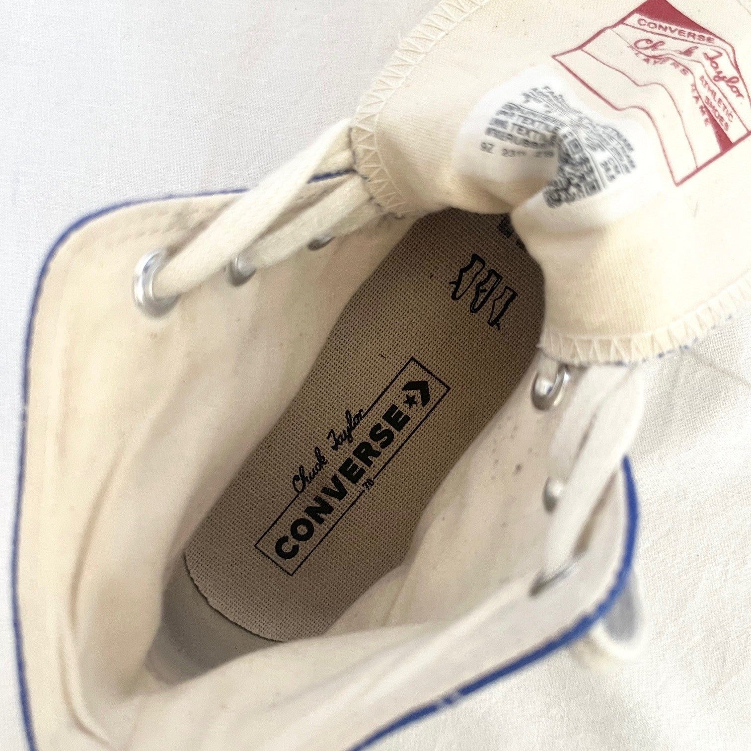 Close-up of a white Converse sneaker with a focus on the brand logo.