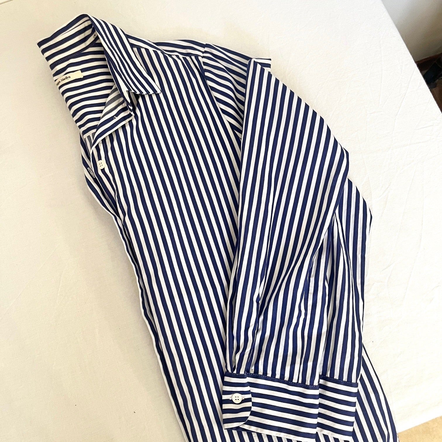 Navy and white striped shirt on a light beige surface