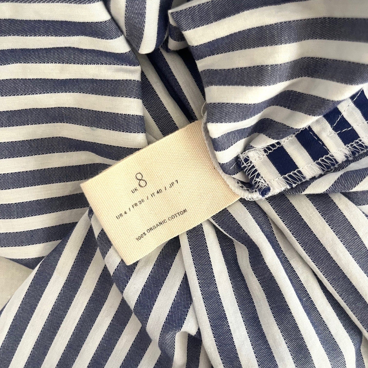 Close-up of a navy and white striped fabric with a tag.