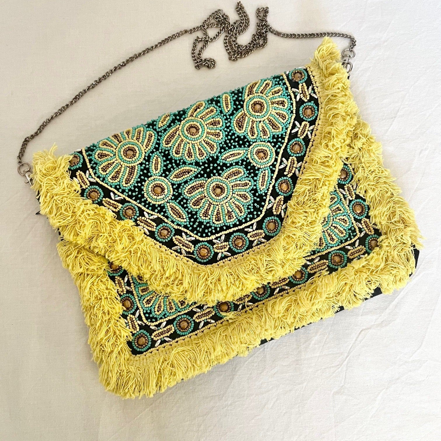 Handbag with floral pattern and yellow fringe on a white background