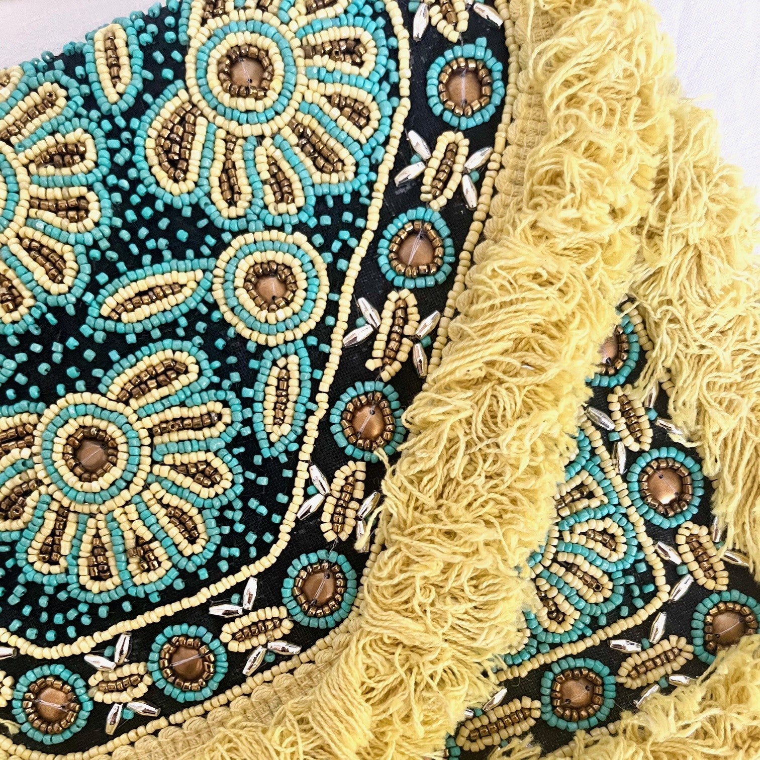Close-up of a decorative fabric with intricate patterns and fringes.